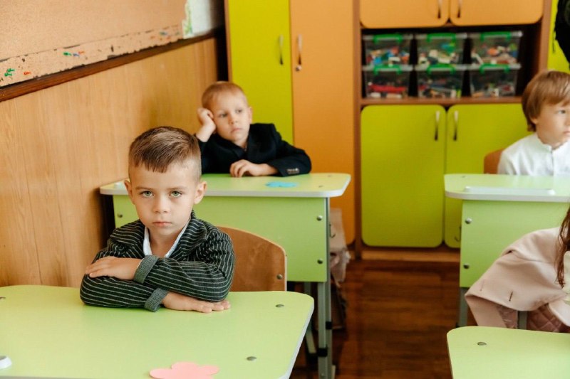 Хлопчик сидить за партою на уроці